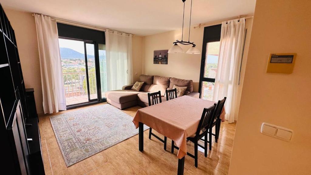 - un salon avec une table et un canapé dans l'établissement Apartamento con vista en L'Hospitalet del Infant, à Hospitalet de l'Infant