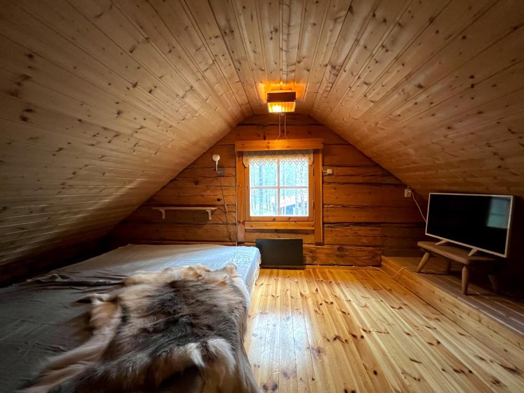 une chambre avec un lit et une télévision dans une cabine dans l'établissement Black Work Levi Autti, à Kittilä
