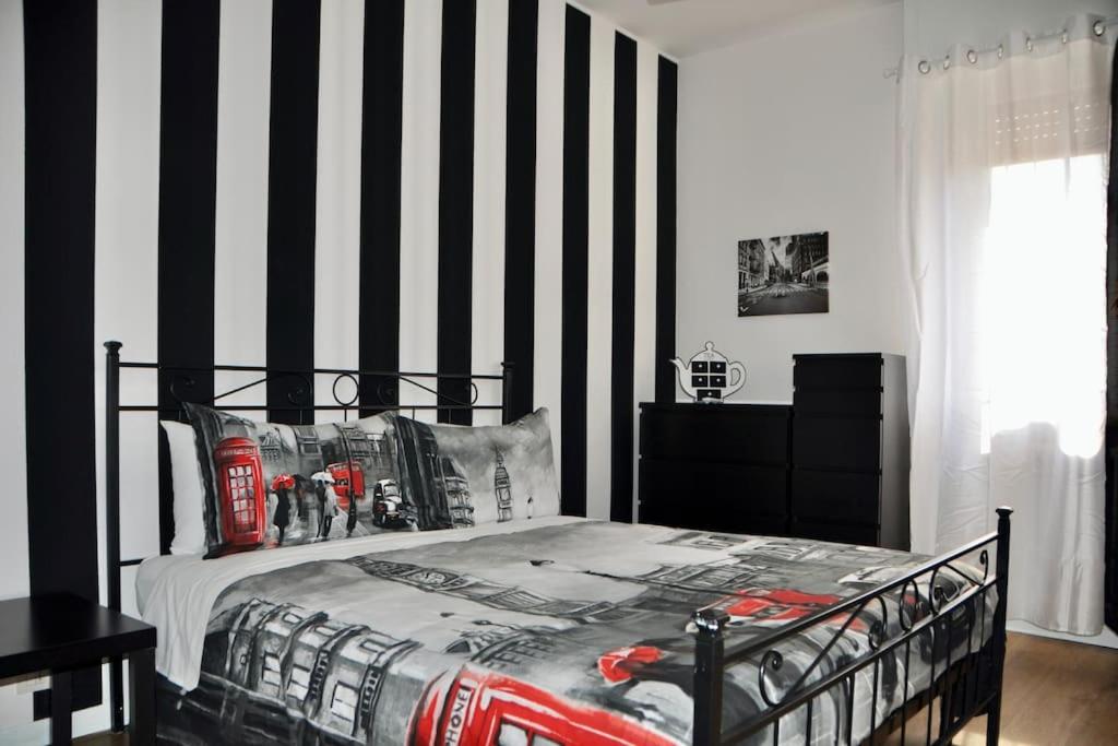 een slaapkamer met een bed met een zwart-witte streepmuur bij M.Aurelio (Nolo) Black & White in Milaan