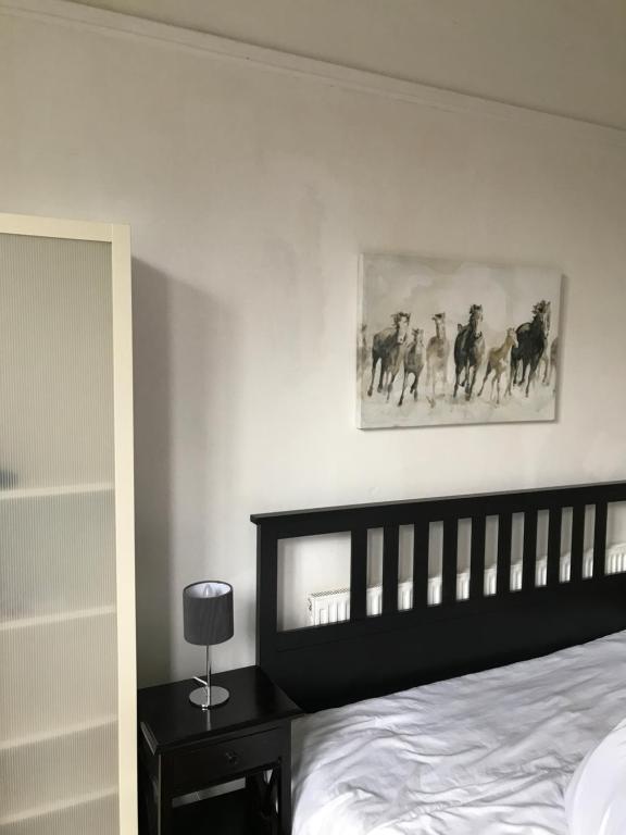 a bedroom with a bed and a picture of horses on the wall at Budget room en-suite 8mins walk to Singleton Hospital, R3 in Sketty