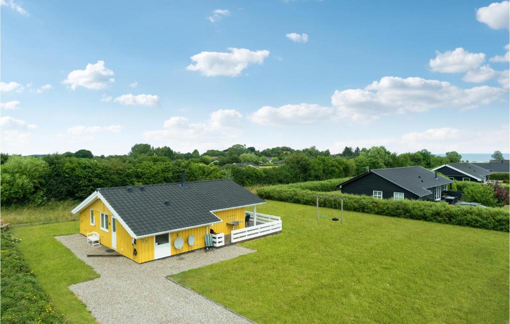 una pequeña casa amarilla en un campo de hierba en Pet Friendly Home In Rudkbing With Sauna en Spodsbjerg