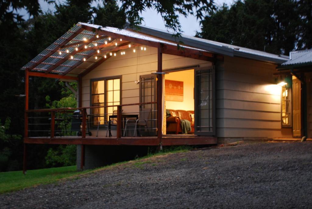 a tiny house with a porch with lights on it at The Bower at Wildside Sanctuary in Bilpin