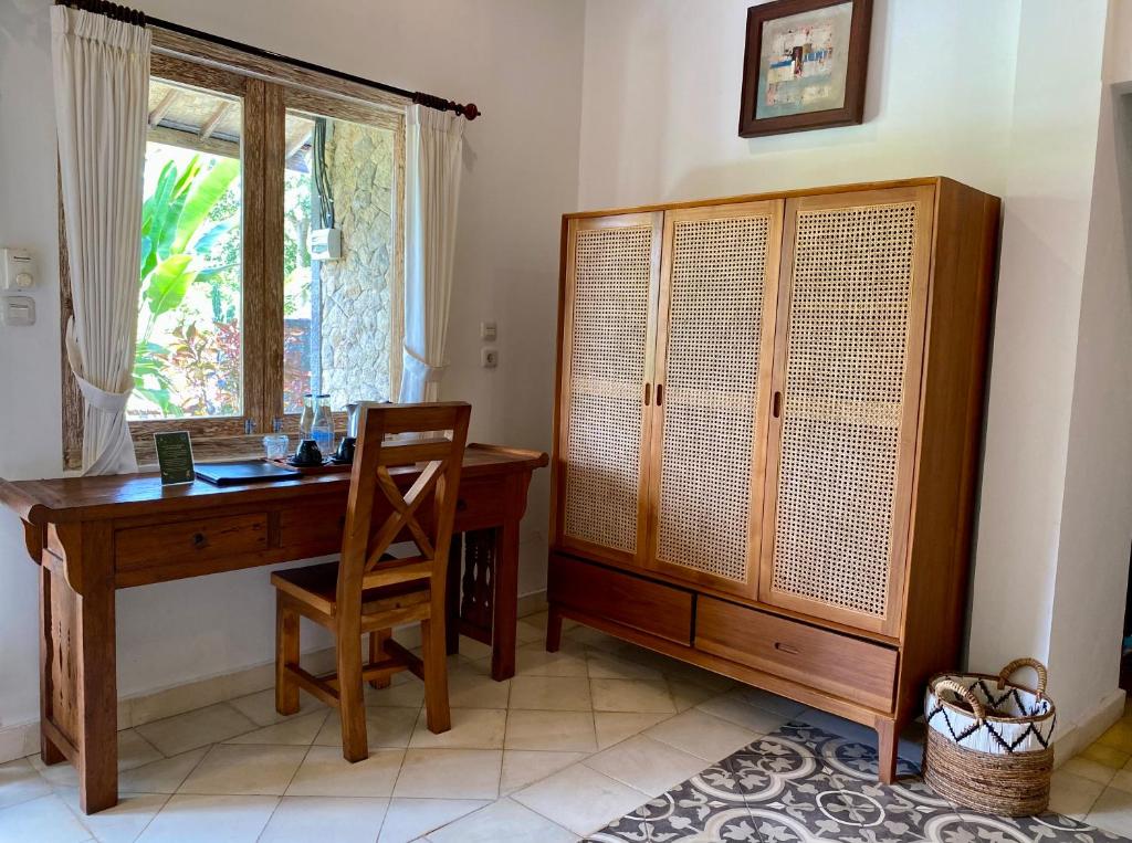 a home office with a wooden desk and a window at Abian Ayu Villa in Sidemen