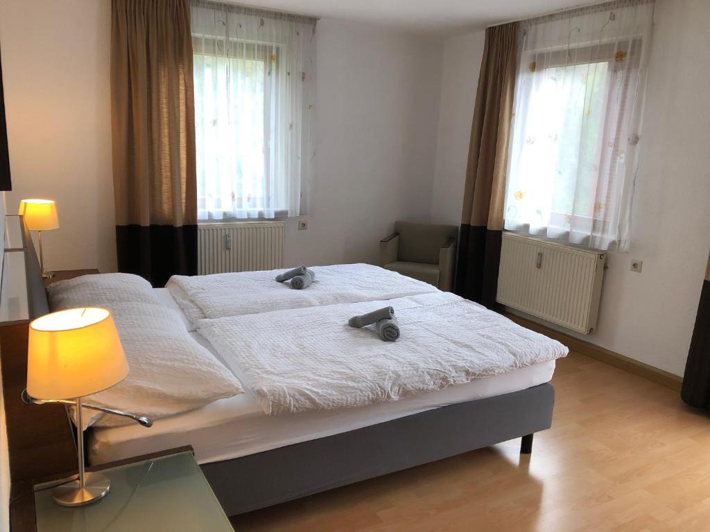 a bedroom with a bed with a lamp and windows at Ferienwohnung mit 1 Schlafzimmer in Altensteig