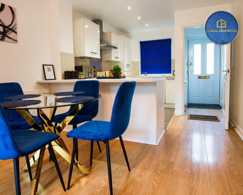 a kitchen and dining room with blue chairs and a table at 2 Bedroom House By Cabral Properties Monthly special price in Reading