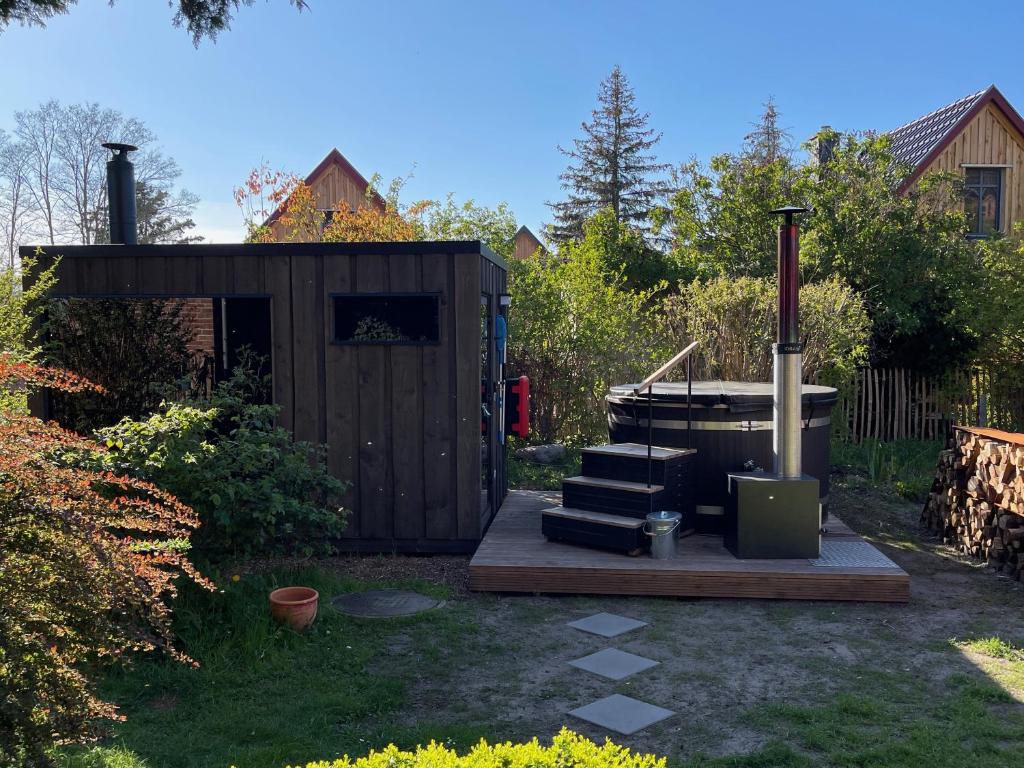 a backyard with a hot tub and a wooden shed at traumHaff- Endless Summer Loft, privates NORDICSPA, Kamin, Hund, 400m zum Wasser in Rieth