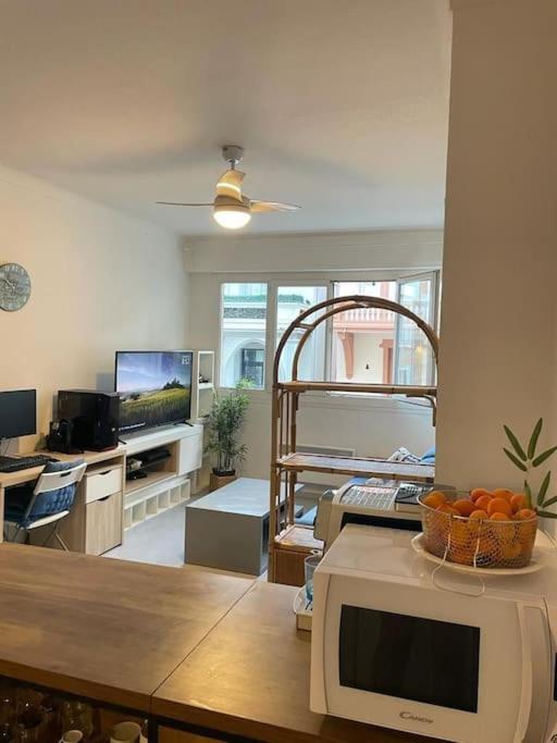 Il comprend un salon avec une télévision et un four micro-ondes. dans l'établissement Appartement 2 pièces 37m2,350m de la plage, à Nice