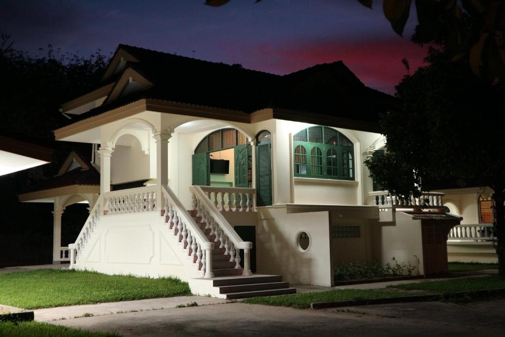 a white house with a green door at night at Bann Mangkud Khaolak in Khao Lak