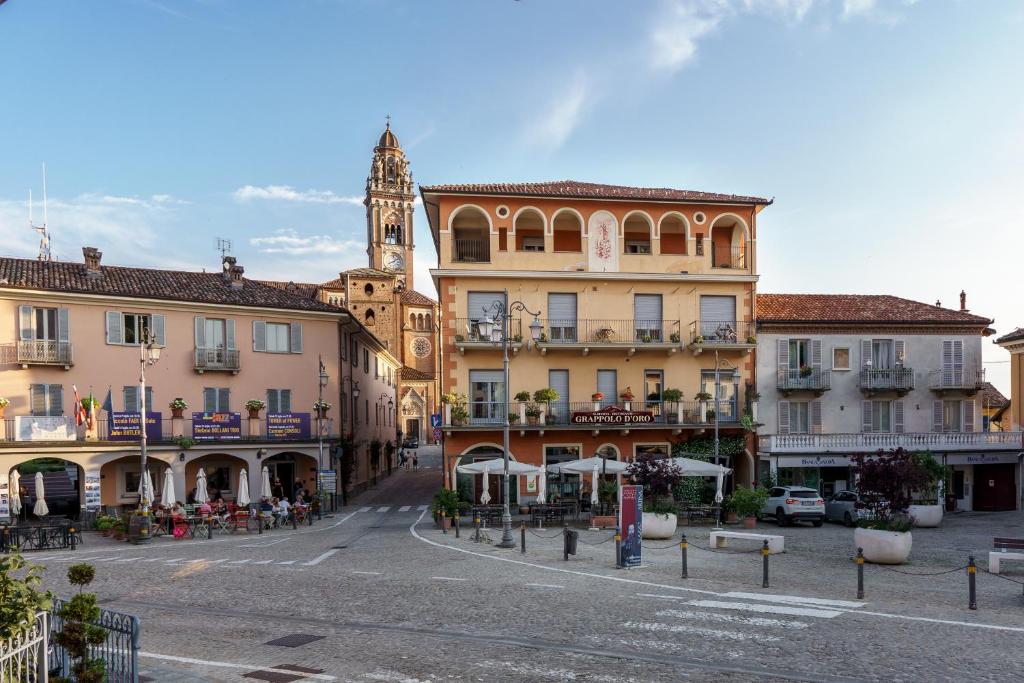 una calle de la ciudad con edificios y una torre del reloj en Hotel Il Grappolo D'Oro, en Monforte dʼAlba