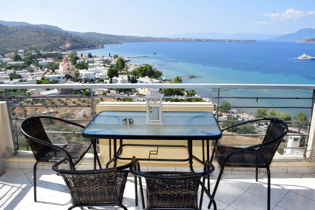 a table and chairs on a balcony with a view of the water at Sea View Luxury Maisonette in Kapótidhes