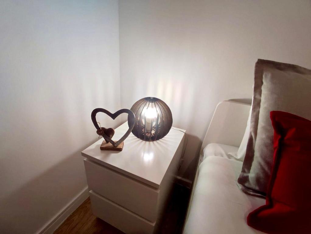 Red Passion Apartment في لشبونة: طاولة مع مصباح على شكل قلب وسرير