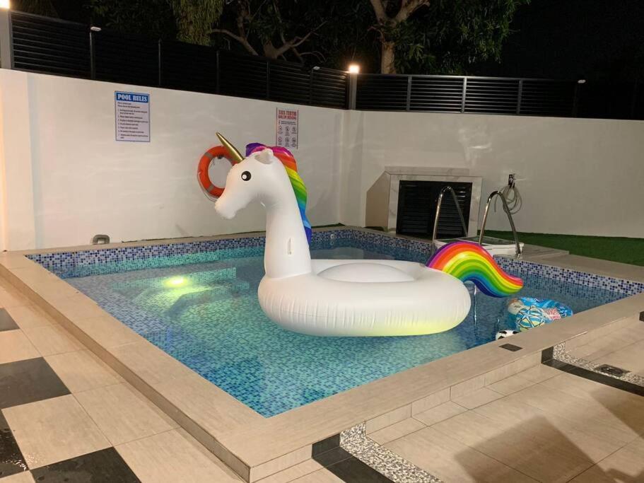 a pool with a unicorn inflatable float in a pool at Abbie's Private Pool Villa Bukit Mertajam Penang in Bukit Mertajam