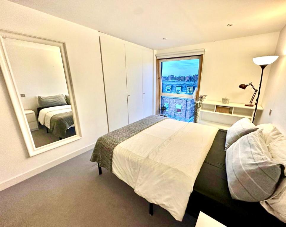 a bedroom with a bed and a large mirror at Double Room to let in stylish cosy flat in Hackney! in London