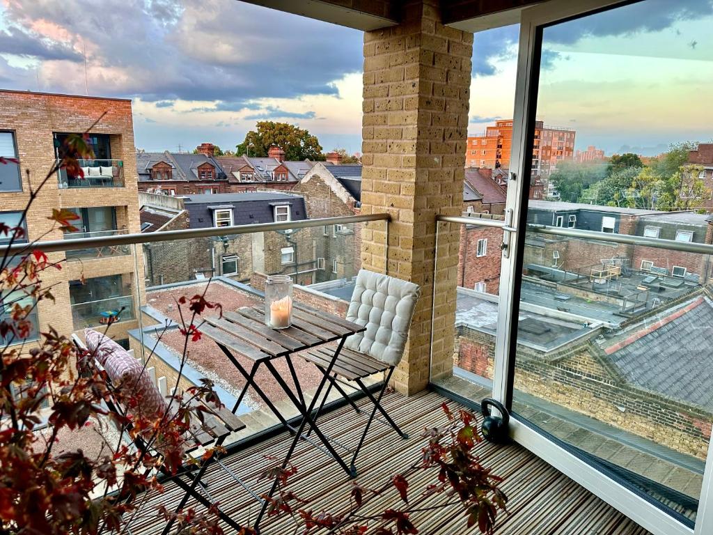 a balcony with a table and a view of a city at Double Room to let in stylish cosy flat in Hackney! in London