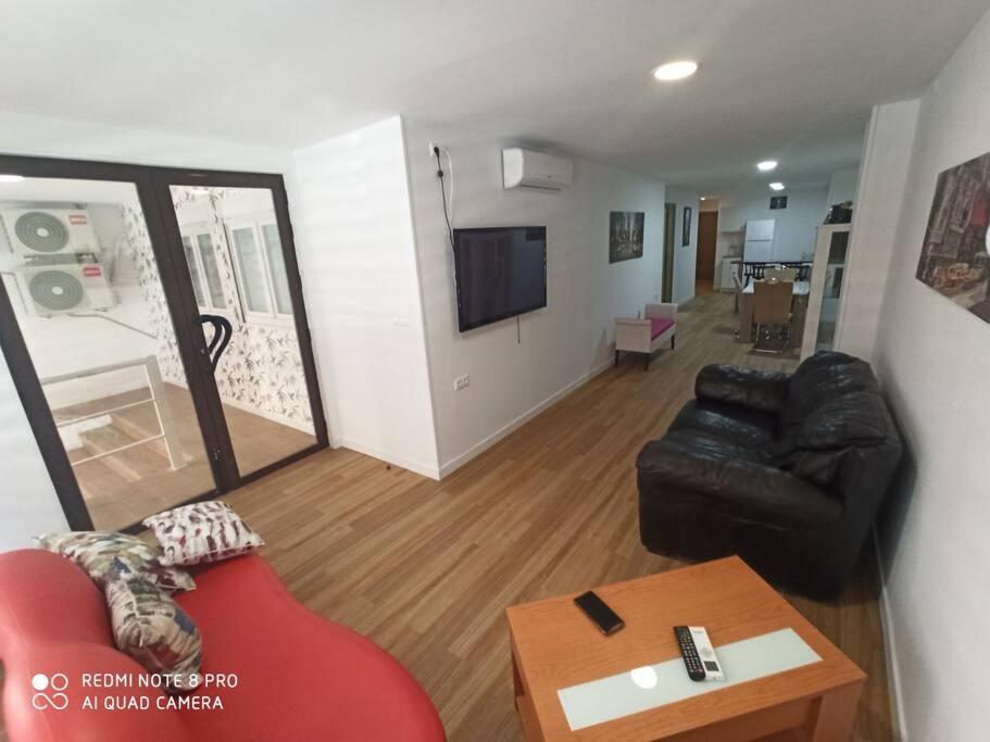 sala de estar con sofá rojo y mesa en Apartamento vacacional, en Torrevieja