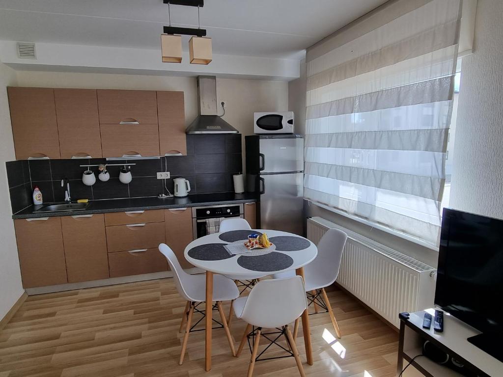 uma cozinha com mesa e cadeiras num quarto em Cozy Sigulda Apartment em Sigulda