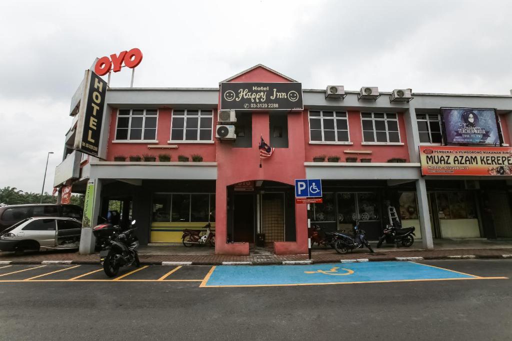 万津Happy Inn Hotel的前面有停车位的大楼