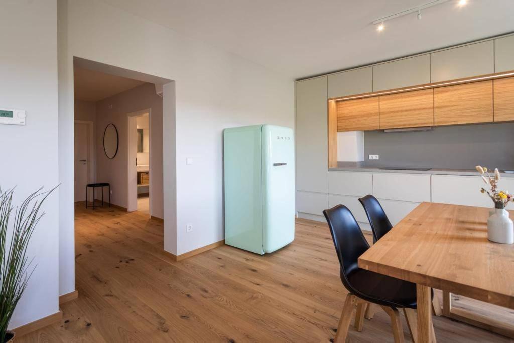 盧森堡的住宿－Renovated 2 Bedroom Apartment with Parking & AC，厨房配有木桌和冰箱。