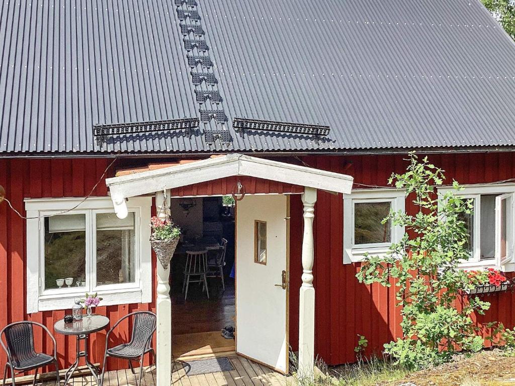 une maison rouge avec une porte blanche et une table dans l'établissement Holiday home Gnesta II, à Gnesta