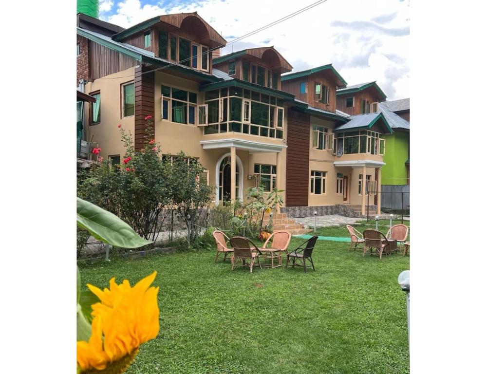 a group of houses with chairs and tables in the yard at Grand Mala Resorts, Pahalgam in Pahalgām