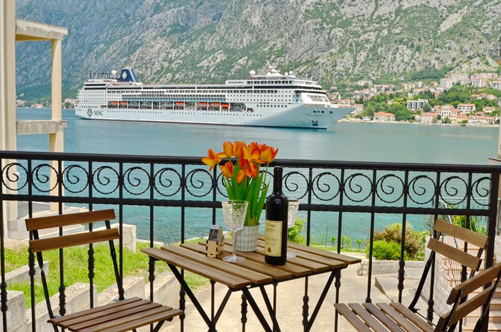 een balkon met een tafel en een cruiseschip in het water bij Apartments Jankovic in Kotor