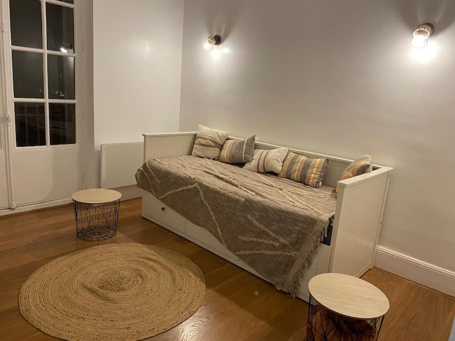 ein Schlafzimmer mit einem Bett mit 2 Tischen und einem Teppich in der Unterkunft Logement 10 min des sanctuaires in Paray-le-Monial