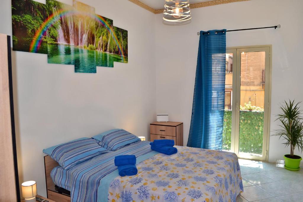 a bedroom with a bed with a rainbow painting on the wall at Happie Casa Stazione Centrale in Palermo