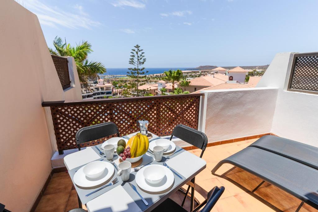 d'une table et de chaises sur un balcon avec vue sur l'océan. dans l'établissement Albatros 433B Holiday Home in Tenerife South, à San Miguel de Abona