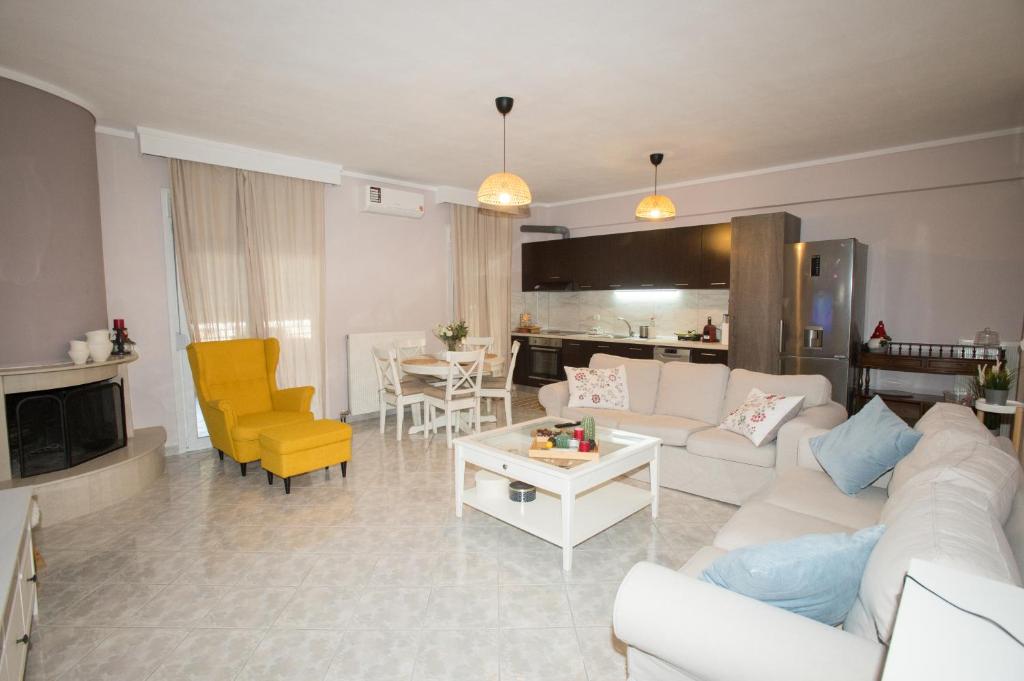 a living room with a white couch and yellow chairs at Fully equiped and homey apartment Peraia in Perea