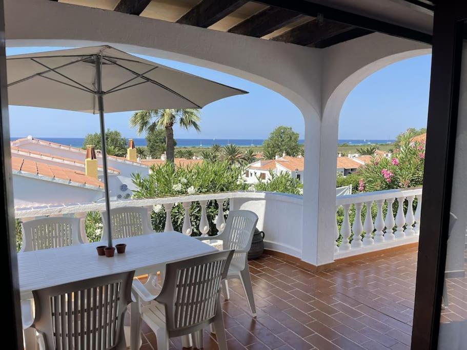 een veranda met een tafel en stoelen en een parasol bij 3 Bedroom Villa, San Jaime, Son Bou in Son Bou