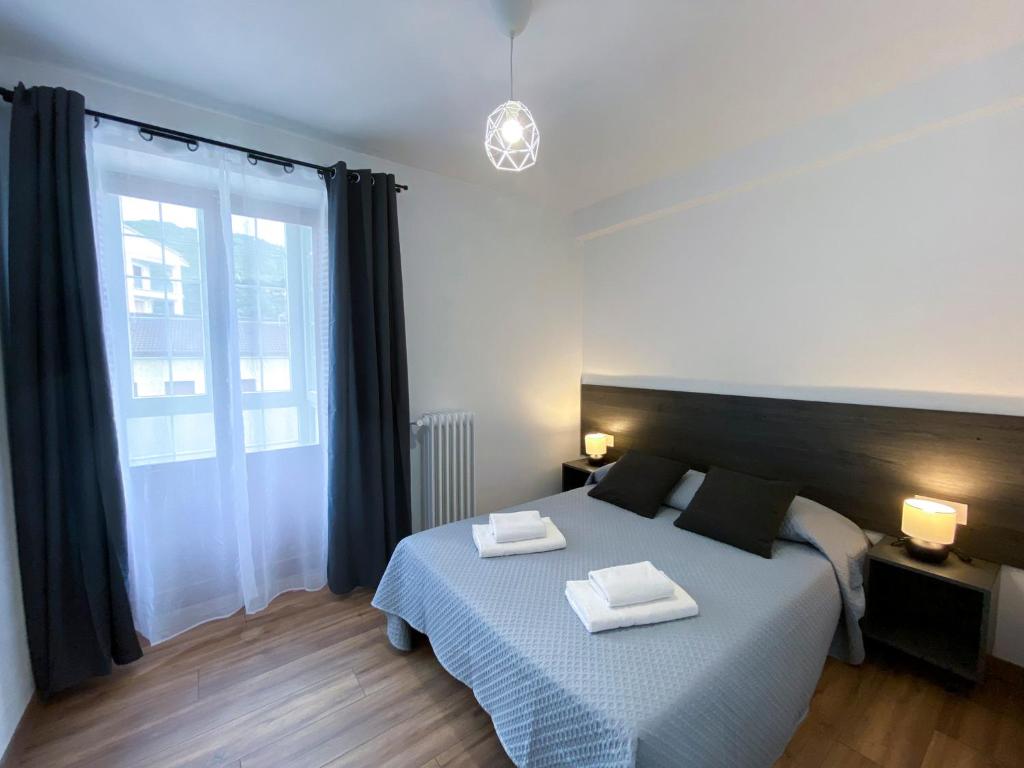 1 dormitorio con 1 cama con 2 toallas en Apartamento Ara Boltaña, en Boltaña