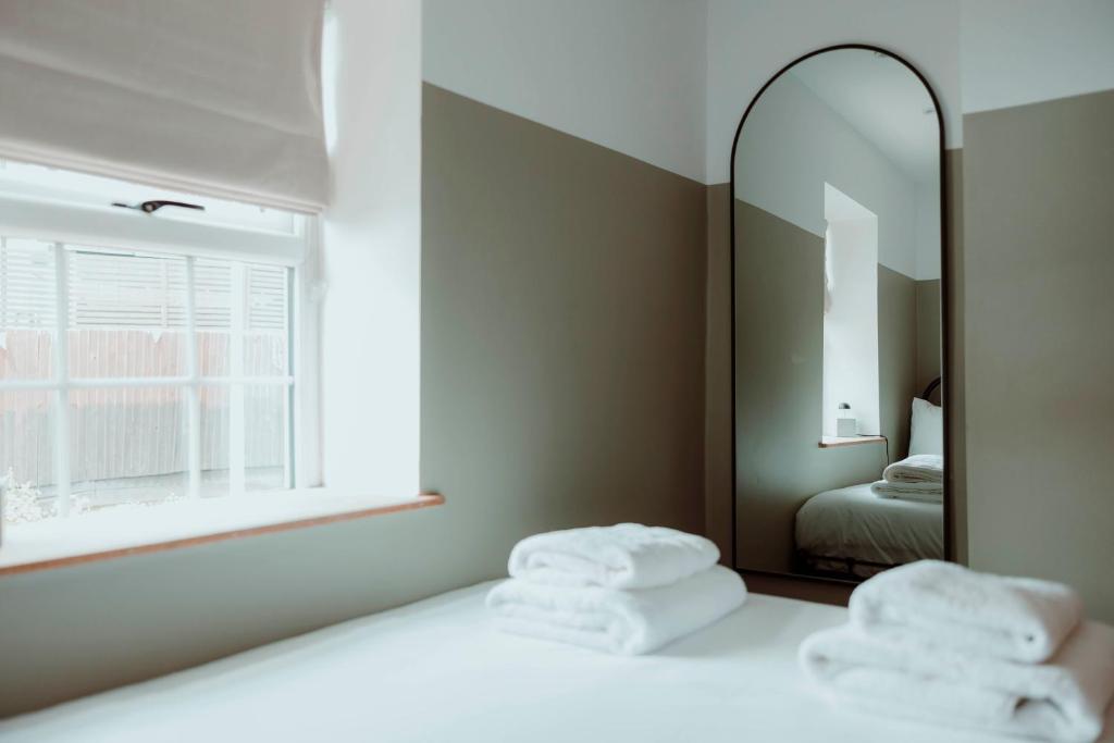 dwa ręczniki na łóżku przed lustrem w obiekcie Brecon Cottage A Luxury Hikers Retreat w mieście Brecon