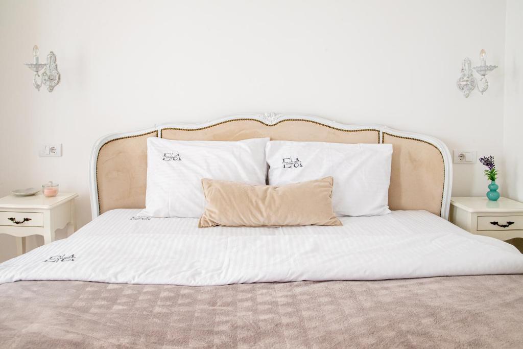 Una cama con sábanas blancas y almohadas. en Etoile City Center Apartments, en Belgrado
