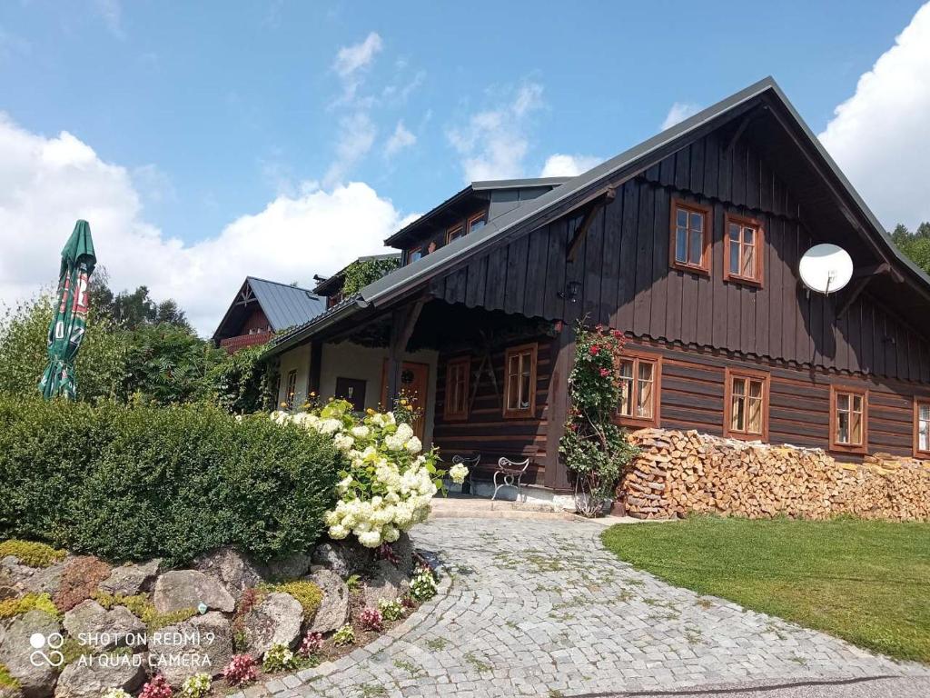 uma grande casa de madeira com um caminho de pedra em frente em U Hübnerů em Albrechtice v Jizerskych horách