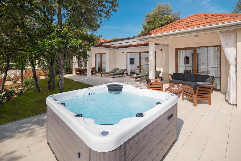 een hot tub op de patio van een huis bij Luxury Glamping Bay Villas Porto Bus in Bale