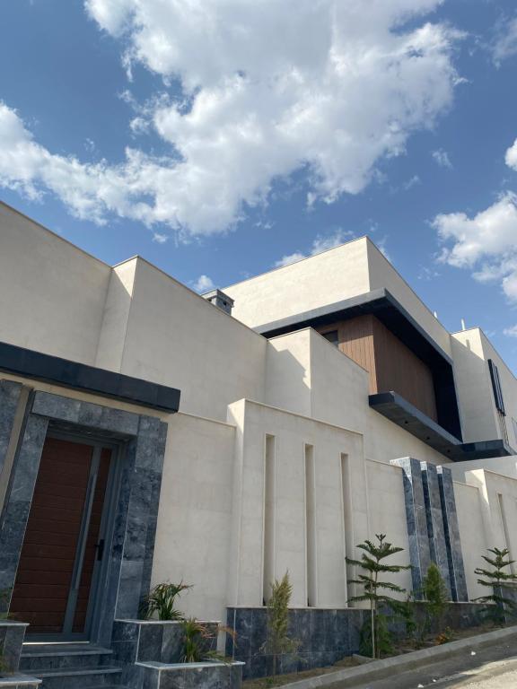 un grand bâtiment blanc avec un ciel au fond dans l'établissement dana hotel apartments, à Taif