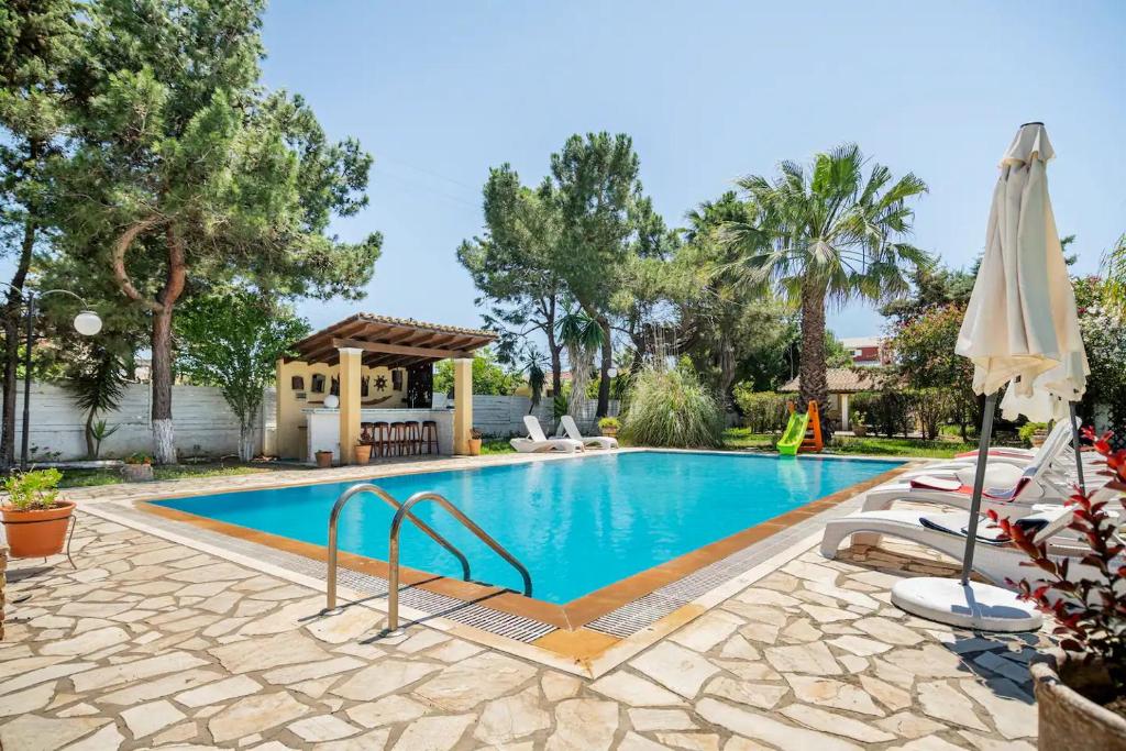 una piscina con cenador y árboles en St. George Villa, en Agios Georgios