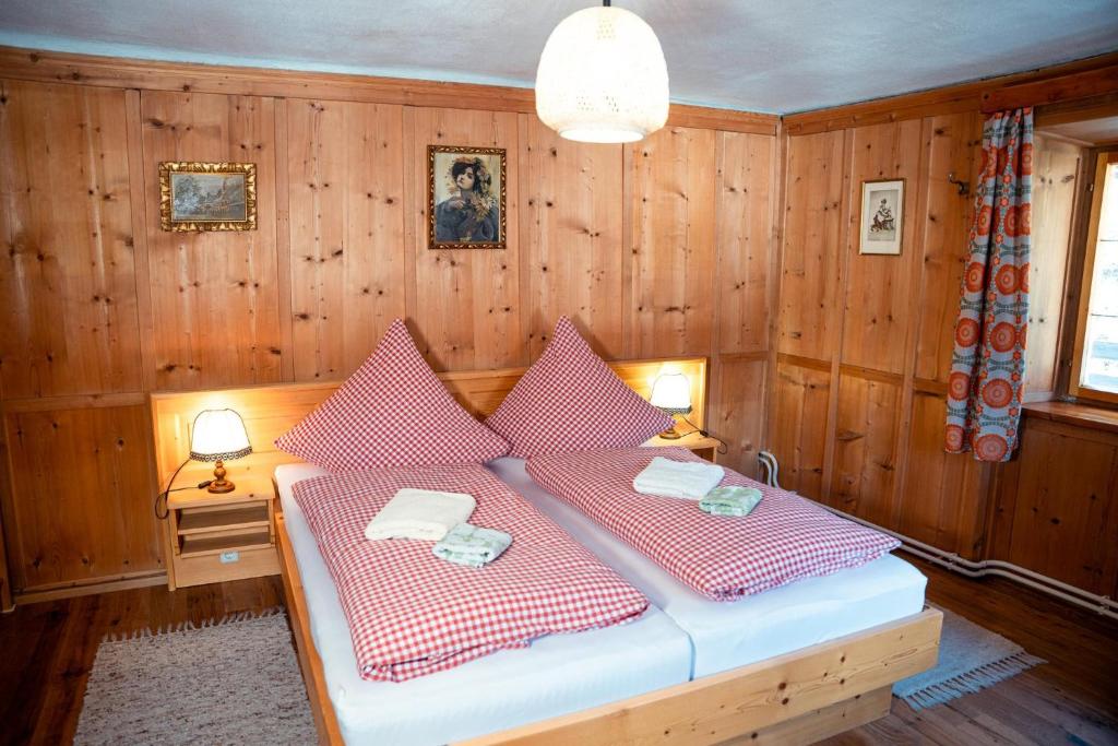 a bedroom with a bed with red and white pillows at Landhaus Geierwally in Elbigenalp