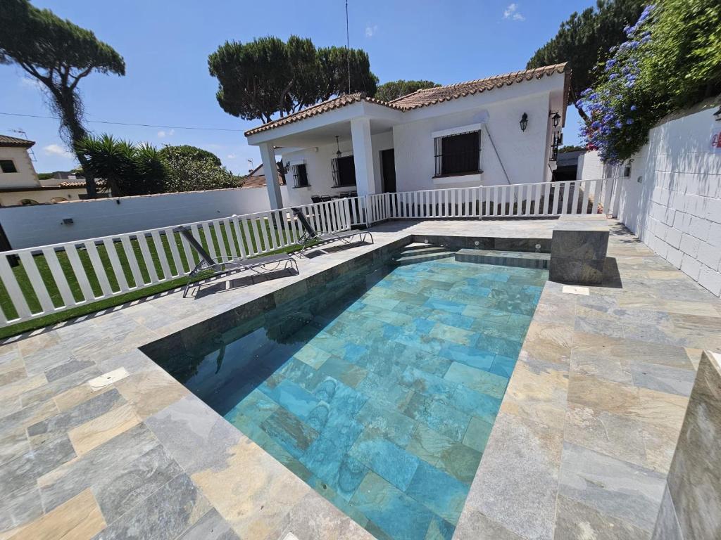 a swimming pool in front of a house at Casa piscina in Chiclana de la Frontera