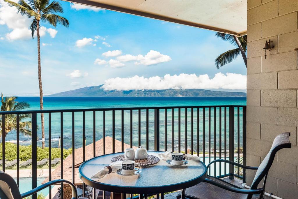 une table sur un balcon avec vue sur l'océan dans l'établissement Noelani 214, à Kahana