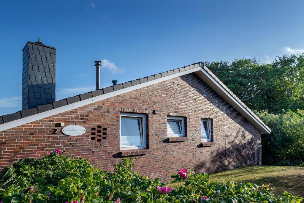 a brick house with two windows and a chimney at Fischer's Hus in Langeoog