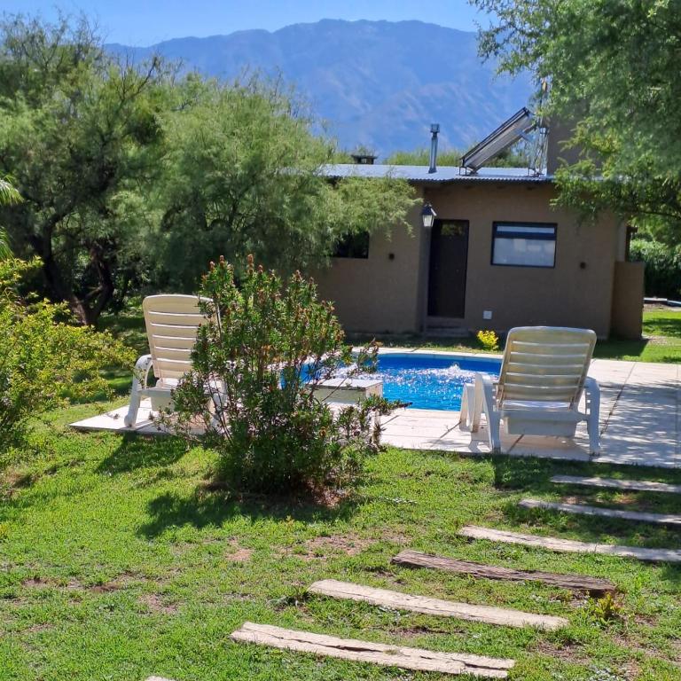 two chairs and a swimming pool in a yard at Cabañas Altos de San Blas in San Javier