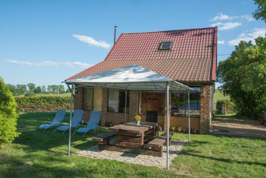 a gazebo with chairs and a table in front of a house at Dom nad jeziorem Granicznym in Stary Żabin