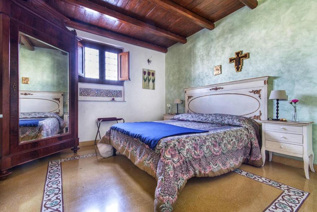 ein Schlafzimmer mit einem Bett und einem Kreuz an der Wand in der Unterkunft Cathedral City Center Palermo 2 in Palermo