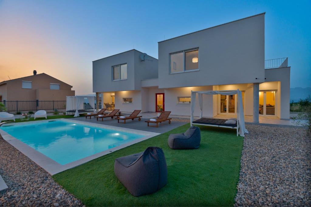 a house with a swimming pool in the yard at Villa Dream Island in Paljuv