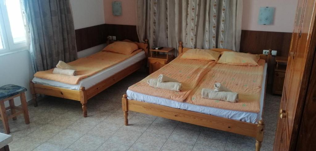 two beds in a hotel room withskirts at Guest House D. Bogdanova in Obzor