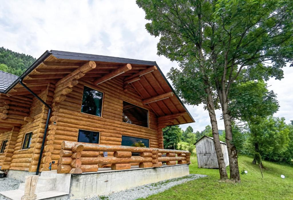 uma cabana de madeira com uma árvore em Cabana Arsita Poienii em Borsa