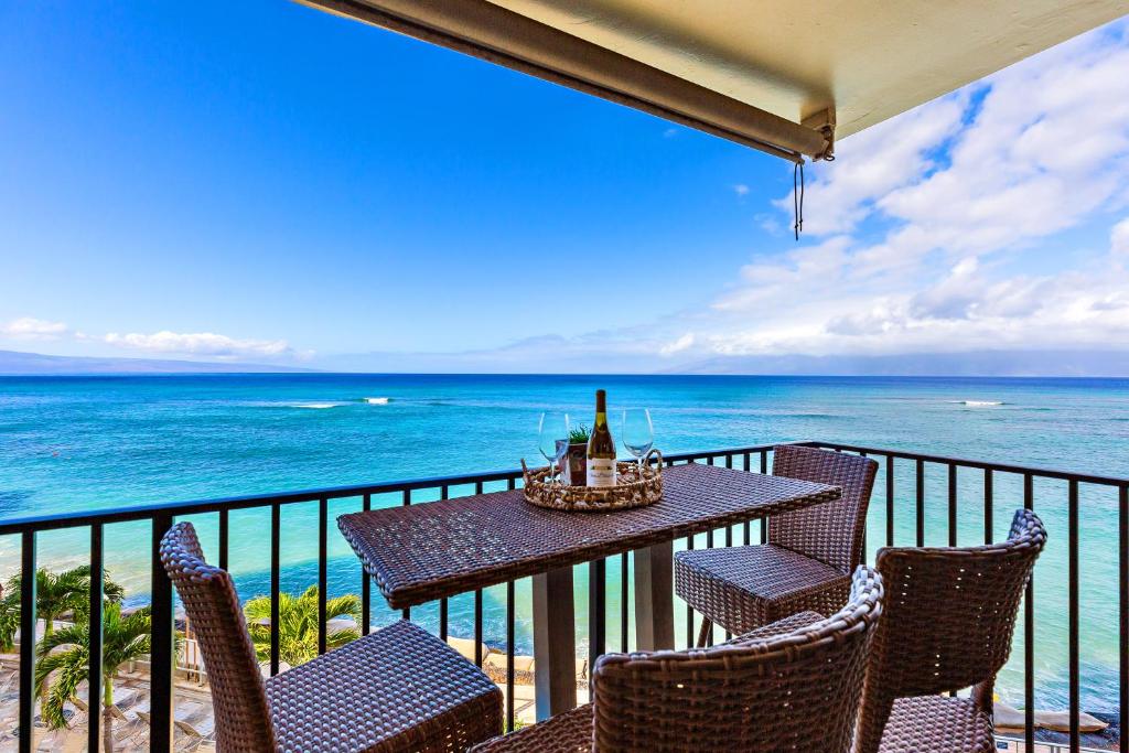 a table and chairs on a balcony with the ocean at Hololani A402 in Kahana