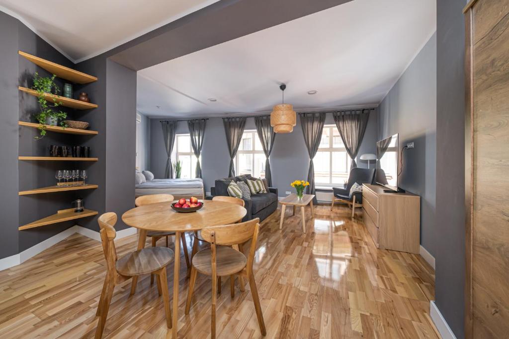 a dining room and living room with a table and chairs at Romantic and spacious apartment in Riga Old Town in Rīga