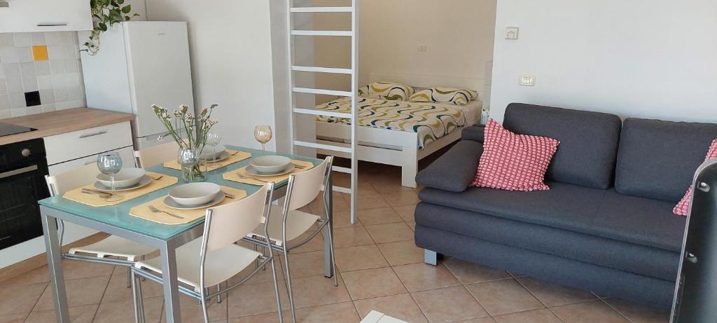 cocina y sala de estar con sofá y mesa en Apartma Vida, en Koper